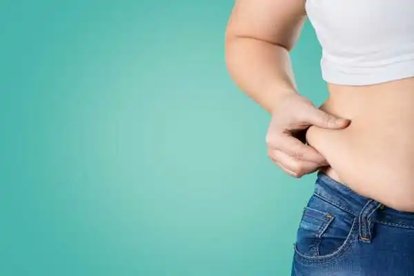 Image of woman pinching her love handles to show weight gain Cheshire